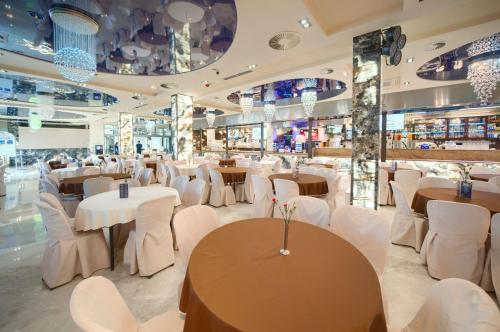 雅罗斯瓦维茨Aquapark Health Resort & Medical SPA Panorama Morska All Inclusive的一间设有白色桌子和白色椅子的餐厅