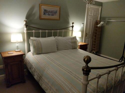 Appletree House的一间卧室配有一张大床,设有木制床头柜