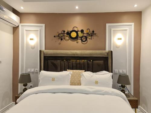 杜阿拉Suna' a Home Bonapriso的卧室配有一张带两个灯的大白色床