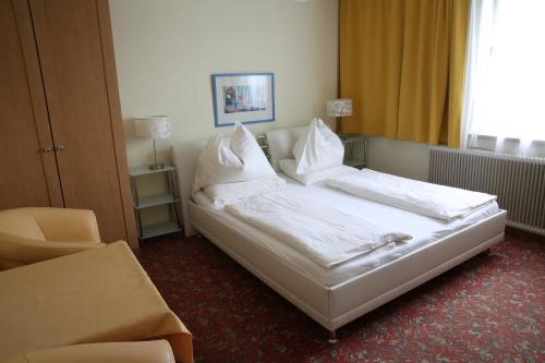 克夫拉赫Hotel Reinisch的一间卧室配有带白色床单和枕头的床。