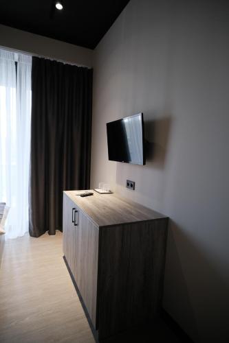 乌日霍罗德Vip Avtim hotel的一间房间,墙上配有电视,设有一个橱柜