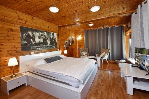 Manot比托诺费度假屋的卧室配有一张白色大床和一张书桌