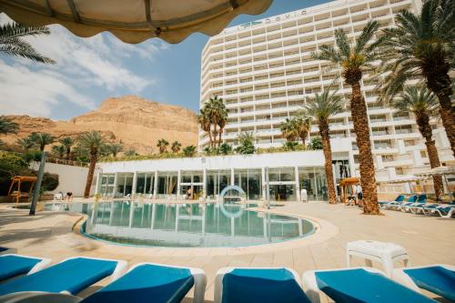 恩波其克大卫死海度假村&Spa酒店的一座拥有游泳池和棕榈树的酒店