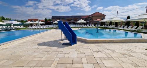 贝尤什Motel LAGUNA的度假村内带蓝色滑梯的游泳池