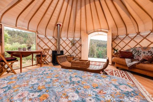 Adventure BayLuxury yurt glamping at Littlegrove的蒙古包内带大床的房间