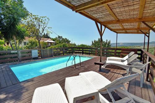 Manot比托诺费度假屋的一个带游泳池、椅子和游泳池的甲板