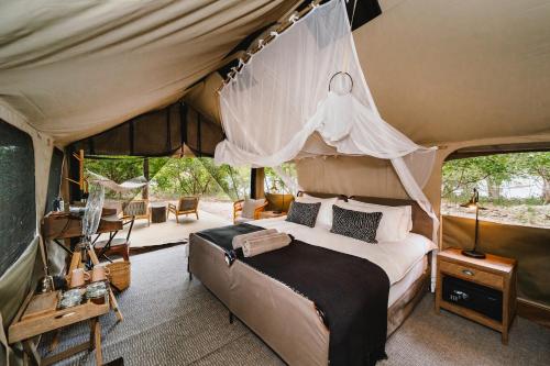 维多利亚瀑布Tsowa Safari Island的帐篷内一间卧室,配有一张床