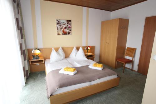 费尔德巴赫Hotel & Frühstückspension Raabtal的一间卧室配有一张床,上面有两条毛巾