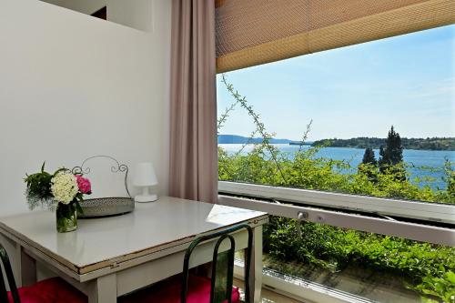 萨罗Villa Raoul的客房设有桌子和享有美景的窗户。