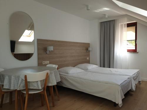 格但斯克Messina Apartamenty Wyspa Sobieszewska的一间卧室配有一张床、一张桌子和一面镜子