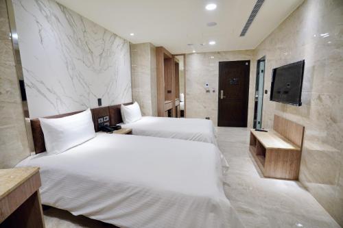 水里乡龍江大飯店的酒店客房设有两张床和电视。