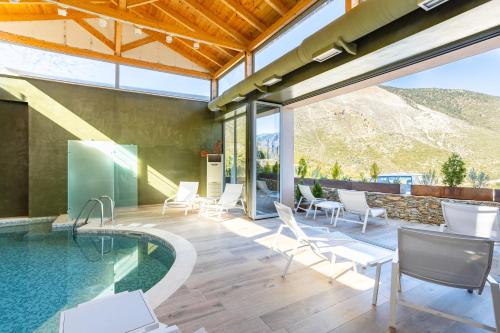 ArtemisíaDenthis Hotel - Taygetos Mountain Getaway的户外庭院设有游泳池、椅子和桌子