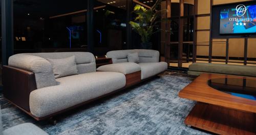 马普托OTIA HOTEL的客厅配有两张沙发和一台电视机