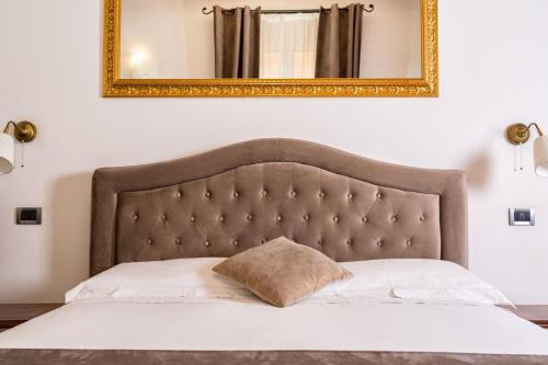 博洛尼亚科斯莫伊B＆B酒店的上面有金色镜框的床