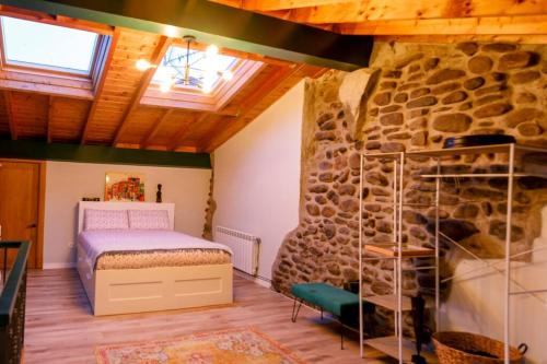 SaroCasa el Envero的一间卧室设有一张床和石墙
