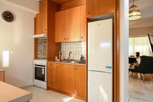 塞萨洛尼基Thessaloniki Center Modern Apartment的厨房配有木制橱柜和白色冰箱。