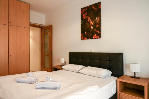 塞萨洛尼基Thessaloniki Center Modern Apartment的一间卧室配有一张床,上面有两条毛巾