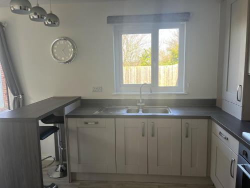 威勒尔Remarkable 3-Bed House in Wirral的厨房设有水槽和窗户。