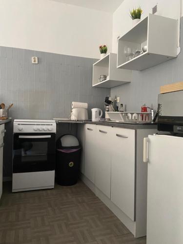 马赛Studio indépendant dans maison de ville, au calme的厨房配有白色橱柜和黑烤箱。