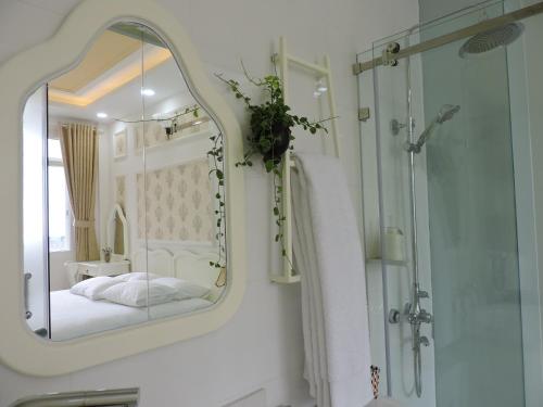 胡志明市Chez Lotus Rose的一间带镜子、一张床和淋浴的浴室