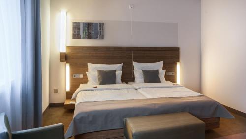 科隆城市宫殿酒店的一间卧室配有一张大床和木制床头板