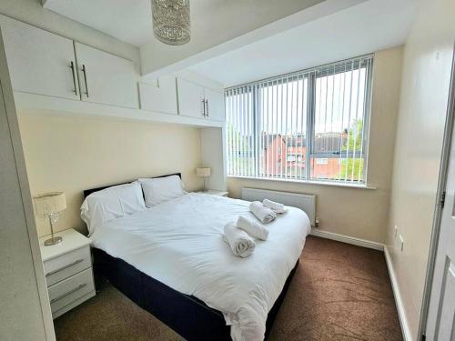 利物浦Baltic Gem 4 Bedroom Townhouse with free parking的卧室配有带毛巾的大型白色床