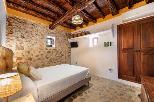 圣埃乌拉利亚Can Mateu的一间卧室配有一张床和一个木制橱柜