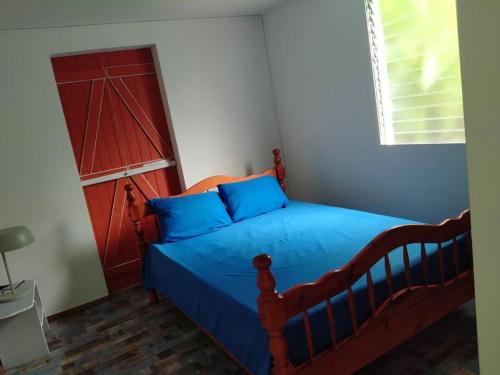 旧阿比唐Maison familiale et authentique的一间卧室配有一张蓝色的床和红色的门