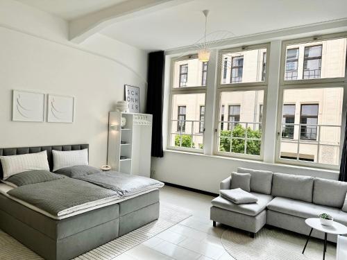 莱比锡MEOS 2 -Zentrum-Hofblick-Gym-Netflix的一间卧室配有一张床、一张沙发和窗户。