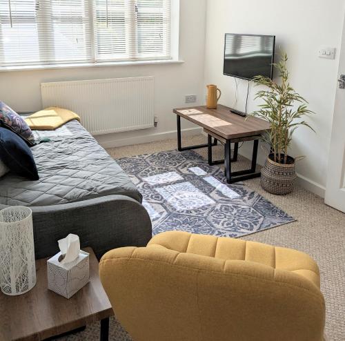 卡迪夫Studio Apartment North Cardiff的客厅配有床、沙发和桌子