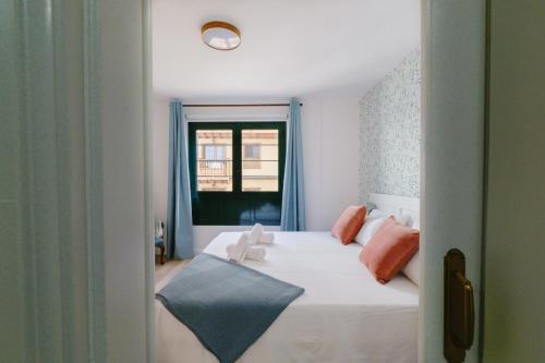 拉克鲁斯Acogedor apartamento en Puerto de la Cruz的卧室配有白色的床和窗户。