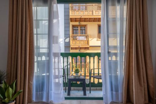 拉克鲁斯Acogedor apartamento en Puerto de la Cruz的阳台的窗户配有窗帘,享有风景。