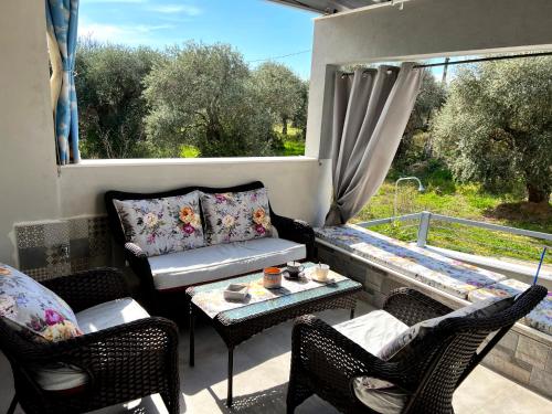 斯卡拉拉乔伊Villa Stemily的阳台配有沙发、椅子和桌子