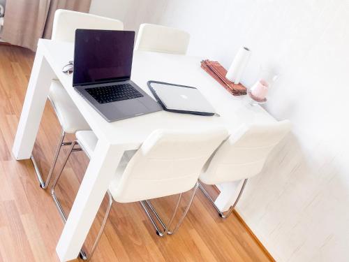 科特卡Ilona Apartments -"Home Away From Home"的一张带白色椅子的白色桌子上的笔记本电脑