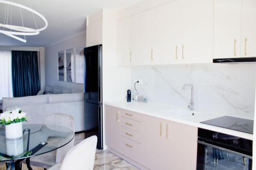 哈尔基斯Εrmis Mini Suite #2的厨房配有白色橱柜和玻璃桌