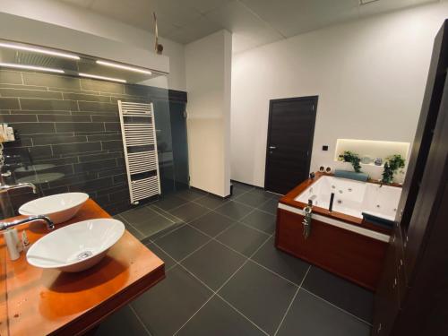 BocholtDe Wellnessloft Bocholt的浴室配有两个盥洗盆和浴缸。