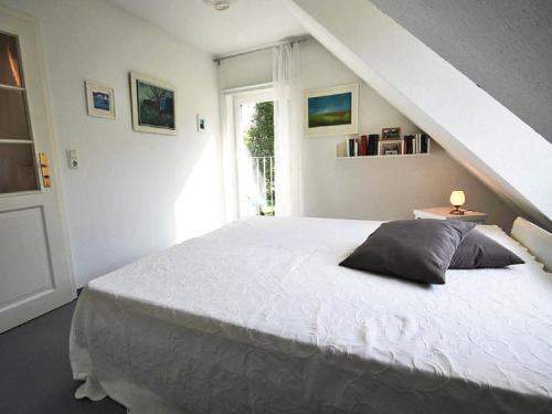 欧巴德伍斯图Ferienhaus Lütt Matten的卧室配有白色的床和窗户。