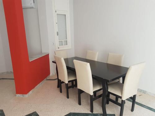 乌姆苏克Djerba La Douce的一间用餐室,配有黑桌和白色椅子