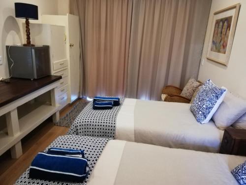 圣弗朗西斯湾Barnard Self-Catering Apartments的酒店客房设有两张床和电视。