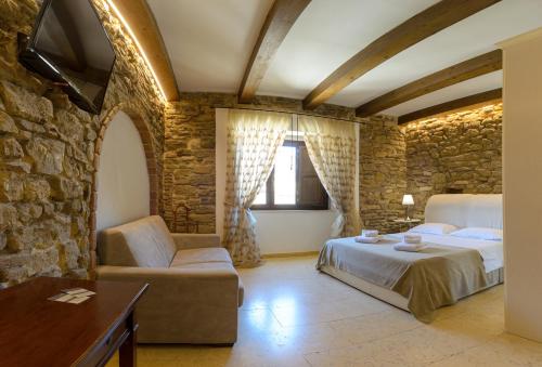 泰尔莫利斯坦泽迪卢多维卡住宿加早餐旅馆的一间卧室设有一张床和石墙