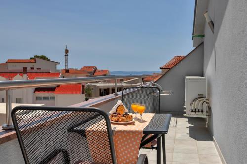 巴什卡沃达Villa Juric的阳台配有桌子和2杯橙汁
