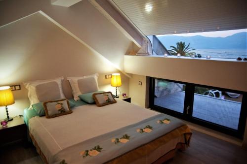 塞利亚尼蒂卡Seacret Apartments的一间卧室设有一张大床和大窗户