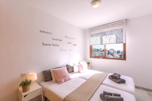 内尔哈Andaluz Apartments Mar de Nerja的墙上有字的房间里,有两张床
