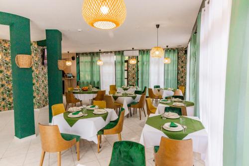 赫尔采格诺维Hotel Vila Hedonija的餐厅设有桌椅和绿色的墙壁