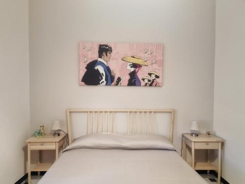 卡莫利Oltremare的卧室配有一张床,墙上挂有绘画作品