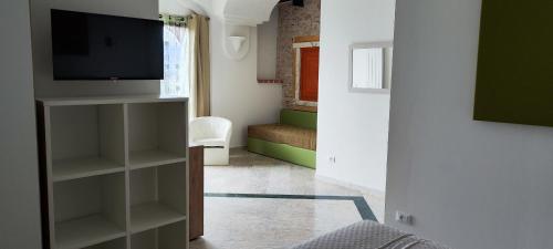 拉奎拉Il Querceto Delle Marine的带电视的客厅和配有床的房间