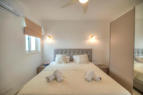 克伦蒂Seaside apartment in the heart of Xlendi Gozo的一间卧室配有一张带两个枕头的床