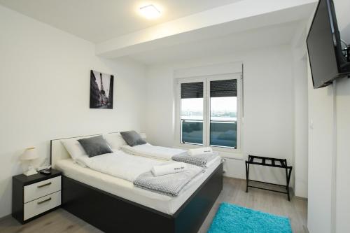 克拉多沃Apartman Klara的白色的卧室设有床和窗户