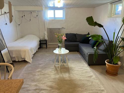 哥德堡Central living with many beds and private garden!的客厅配有沙发和鲜花桌