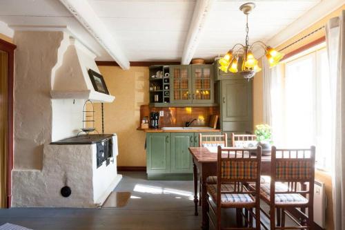波尔沃Torppa Stengård 1700-luvulta的厨房配有绿色橱柜和桌椅